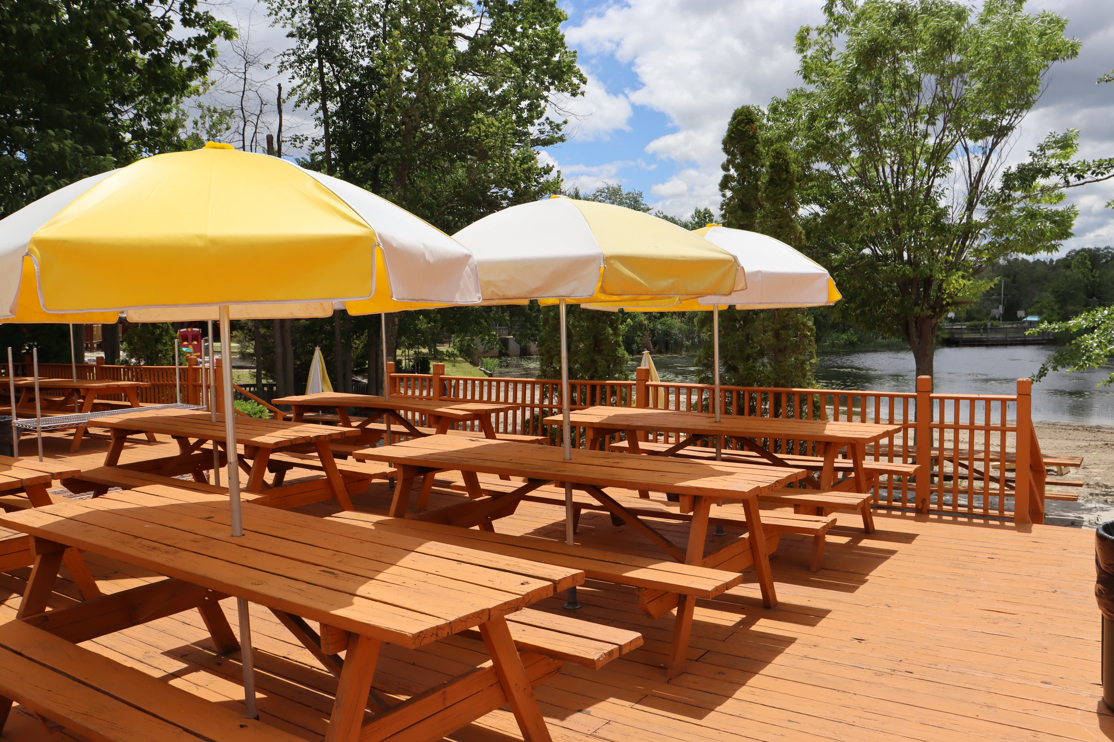 Lakeside deck with picnic tables and yellow umbrellas